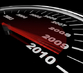 Ein Tachometer mit roter Nadel zeigt auf das Jahr 2010.